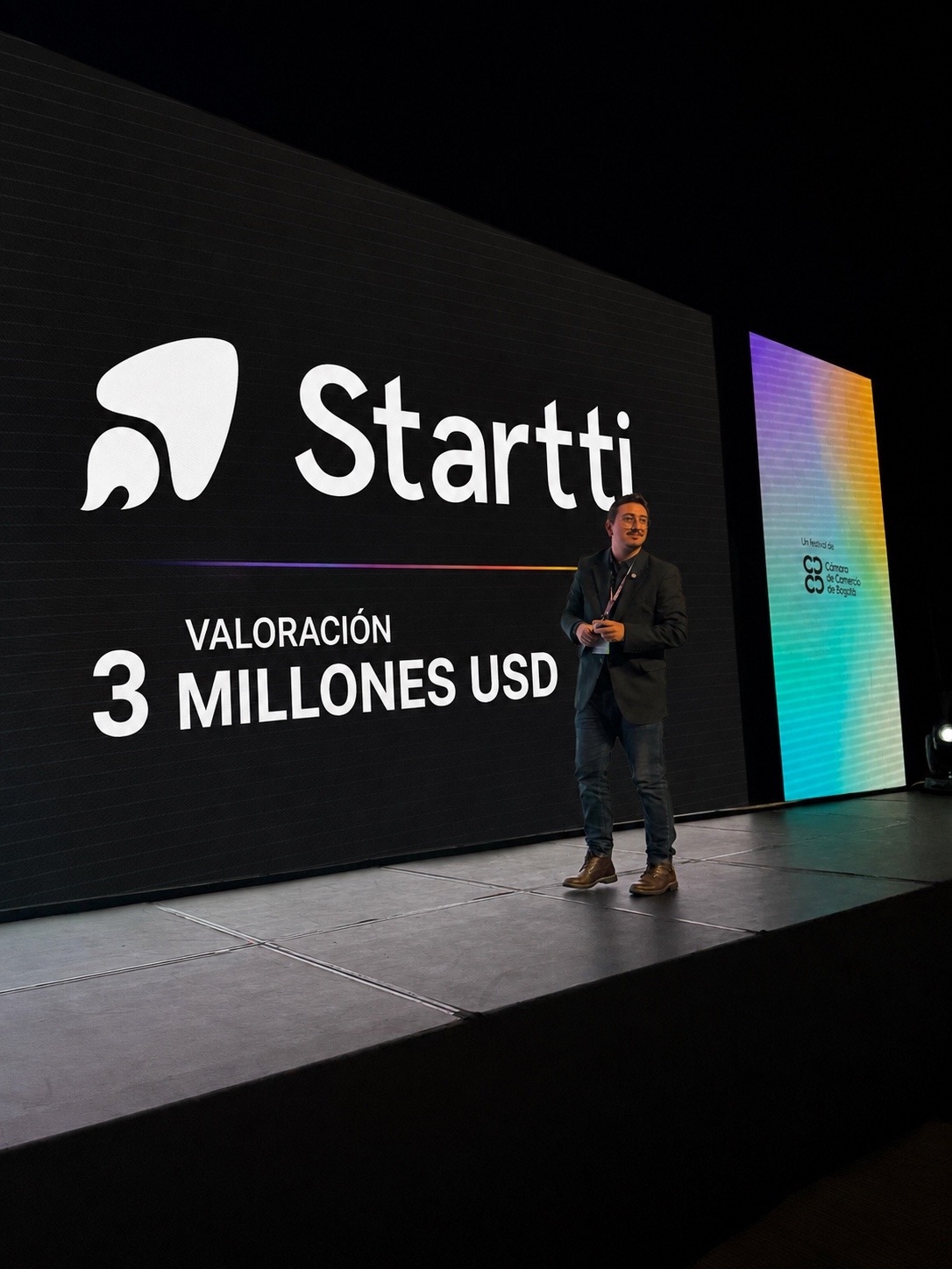 Julián Caicedo, CEO y cofundador de Startti, en el escenario de GOFest 2026 frente a una pantalla que muestra el logo de Startti y el texto Valoración 3 millones USD.